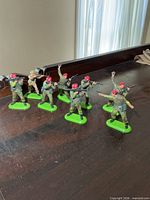 Group view of eight Britains plastic soldiers on green metal bases