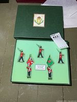 Closed presentation box showing crest on lid and foam insert with five soldiers