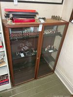 Full view of cabinet showing double glass doors, wood frame, contents not included