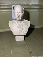 Front view showing full bust, detailing of face, medals and plinth.