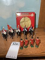 Group shot of five mounted soldiers, four standing soldiers, empty Britains box