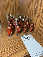 Front angle view of the 20 painted metal toy soldiers grouped together on shelf