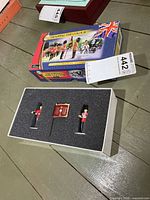 Closed box and open foam insert showing two soldiers and flag
