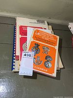 Stack of five military reference books with maxsold tag visible