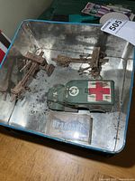 open tin showing all three plastic military models inside