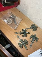Overview of four Crescent cannons and Britains cannon parts bag on shelf