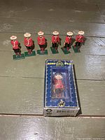 Six loose RCMP figurines and one boxed figurine displayed