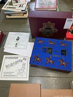 Closed presentation box, paperwork and opened foam tray showing contents
