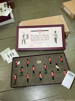 Closed presentation box and open foam tray with 13 band figures