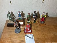 Full group of seven painted metal figurines on bases