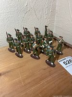 Group shot of all 14 plastic soldiers on wooden surface