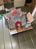 box containing metal castle walls, towers and gate parts