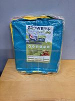 Factory-sealed stack of multicolor grow bags with retail label