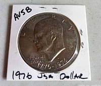 Obverse of Eisenhower dollar in flip, AU58 notation visible