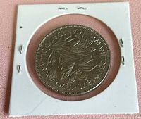 Reverse of 1870-1970 Manitoba Canadian dollar in cardboard flip