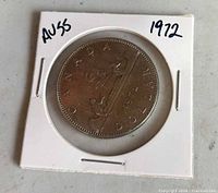 Reverse view of coin displaying canoe design and date