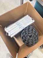 Top view of first box showing five BOGGAN boxes, coiled foam pad and bronze fixture