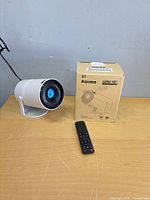 Projector, box, remote on table