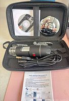 Full kit inside open carrying case showing microscope, stand parts, mini-CD and manual