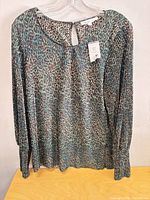 Front view of Cleo Woman leopard print blouse with tag displayed