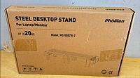Front of sealed Pholiten steel desktop stand box showing product name, capacity, model