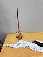 Full view of steel mixer paddle standing upright on table