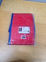 Sealed package showing folded red and blue pool panels with barcode label