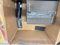 Inside shipping box showing rothoblaas box, aerosol can, drill bit set, black rectangular item