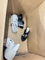 White and black shoes visible in cardboard box