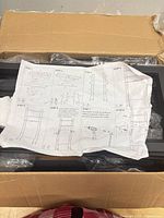 Box with unassembled metal rack parts and instruction sheet visible