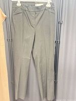 Full view of dark green pants hanging on hanger