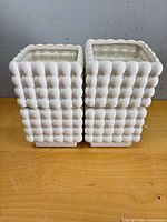 Four white ceramic square pots stacked together