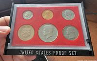 Front view of six-coin proof set in red plastic lens inside black frame