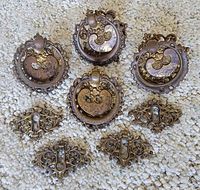 Group shot of four ring pulls and four keyhole plates on carpet