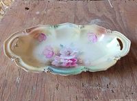 Top view showing floral painting, scalloped rim, handles