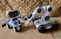 Both robot toys side by side on wooden surface