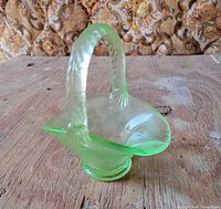 Oblique view of full uranium glass basket showing bowl shape, handle and pedestal