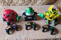 Three Rumble Robots and three controllers on tabletop