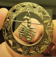Front view showing full brooch, zodiac symbols and scorpion charm