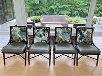 Front view of four side chairs highlighting fabric backs and leather seats