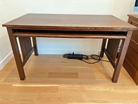 Front view of Stickley wood desk showing top surface and pull-out drawer