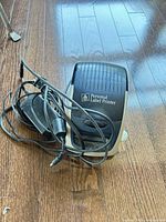 Closed printer with attached power adapter showing overall wear