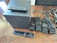 Overall lot showing subwoofer, speakers, remote and cables