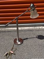 Full view of adjustable chrome table lamp showing arm, base and shade