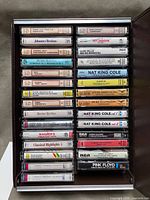 Open carrying case showing 29 cassette tapes with visible titles