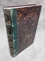 Front and spine view of hardcover showing marbled boards and green leather spine with gilt