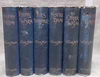 Spine view of all six blue cloth hardcovers with gilt titles