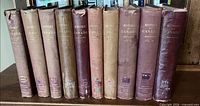 Spines of all ten volumes showing titles, publishers and wear
