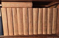 Spines of all 12 volumes showing uniform cloth bindings and gilt titles