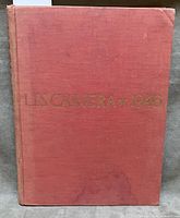 Front cover showing red cloth binding and gilt lettering with water stain